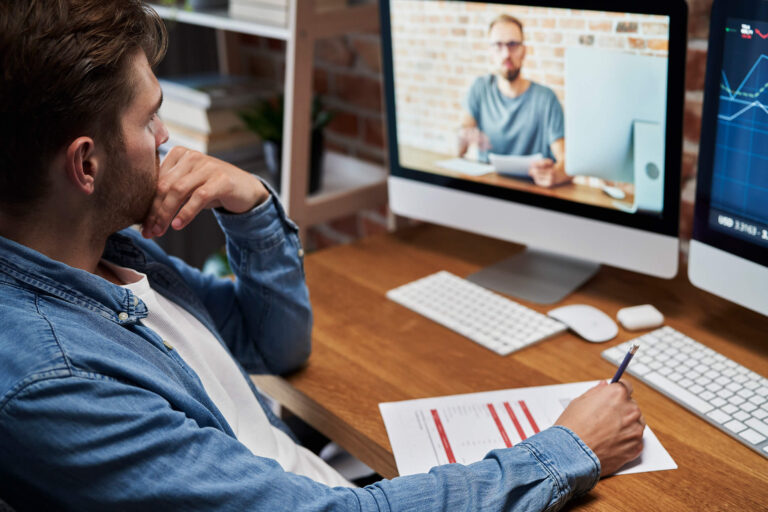 Persona participant en un taller online sobre intel·ligència artificial, prenent apunts davant d’un ordinador – Formació pràctica i personalitzada amb IA