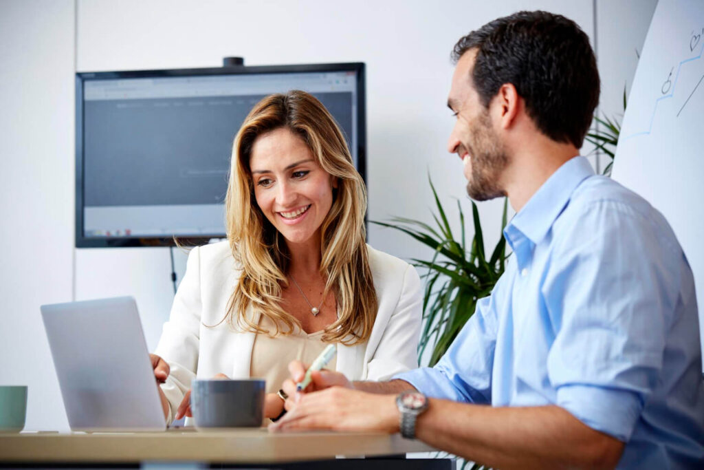 Home i dona professionals somrient a l'oficina, satisfets després de completar la formació en IA per a empreses de Xammar Digital, llestos per aplicar l'automatització al seu negoci a Granollers