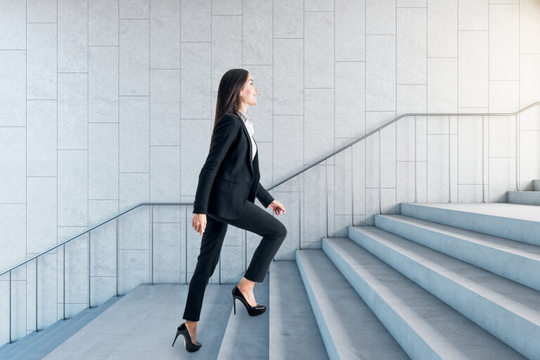 Empresària pujant una escala, simbolitzant el creixement professional de la masterclass d'IA a Mataró.